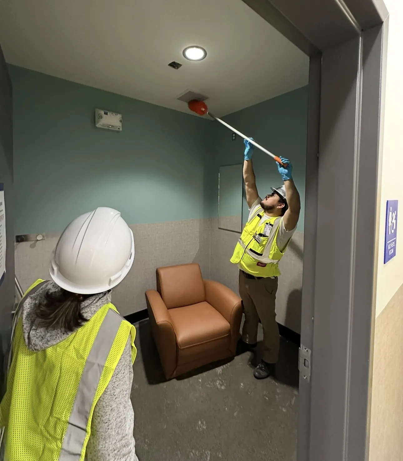 J&A crew dusting a high vent after construction