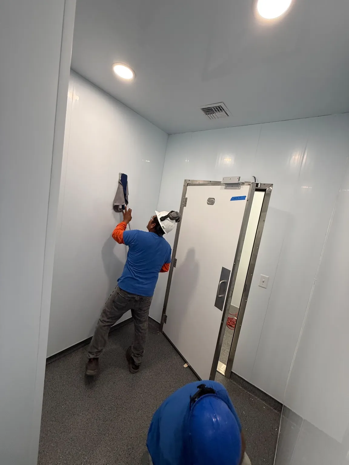 J&A crew member wiping a newly finished interior wall