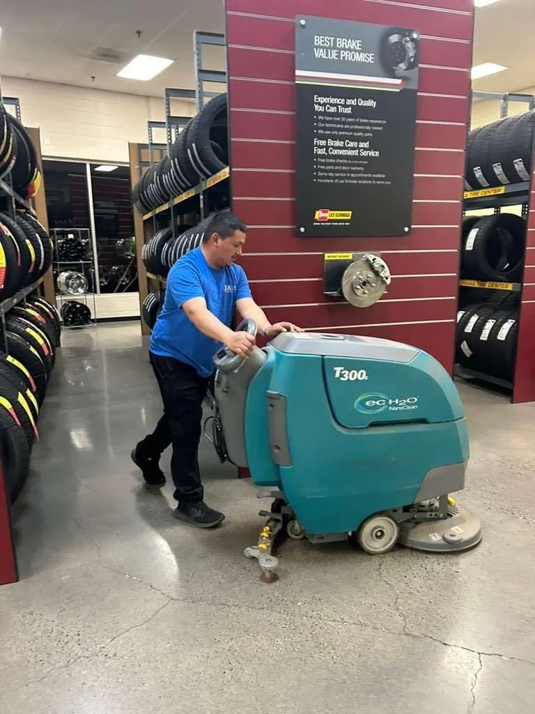 J&A crew member cleaning a commercial floor with professional equipment