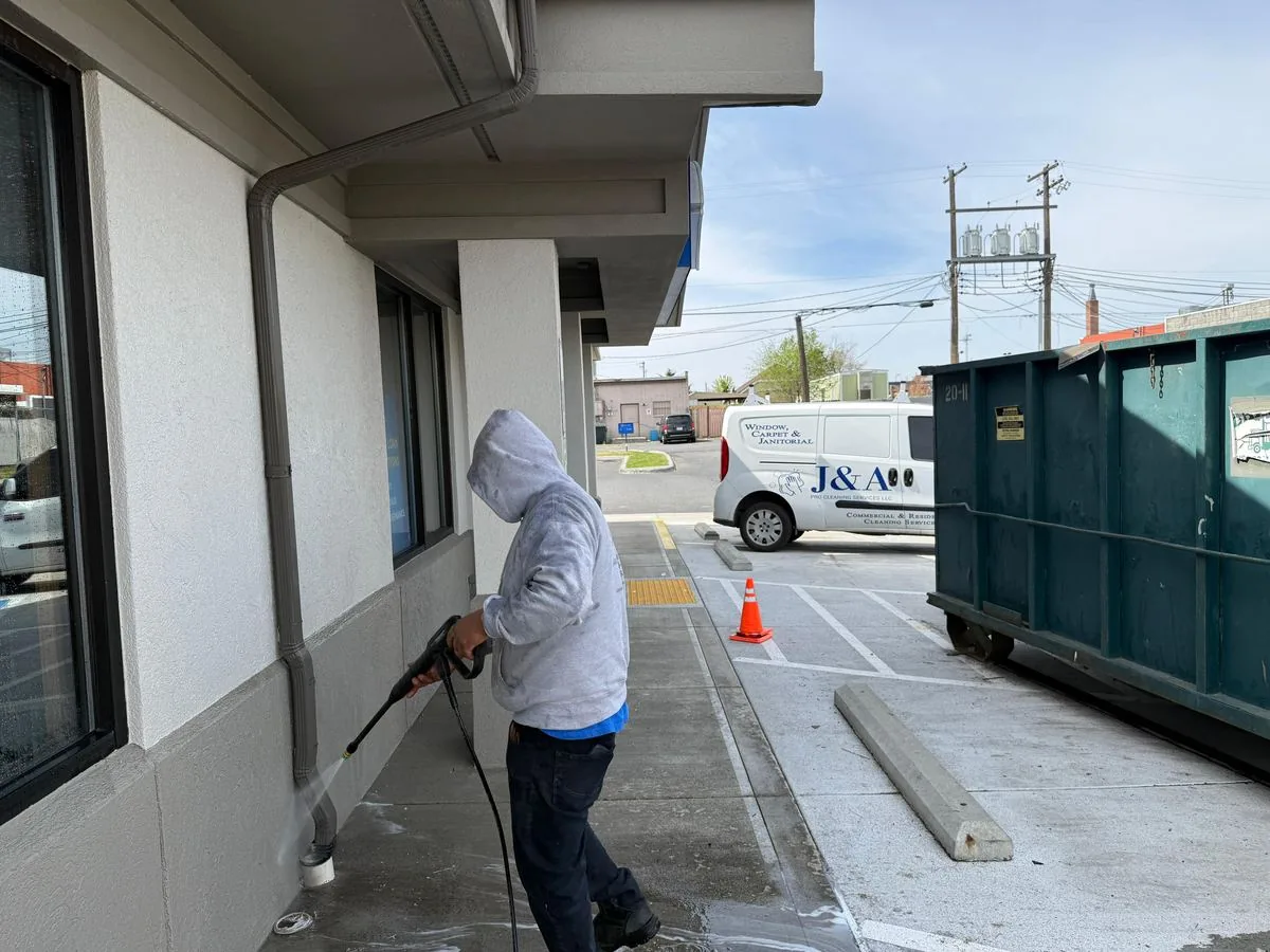 J&A worker pressure washing an exterior walkway